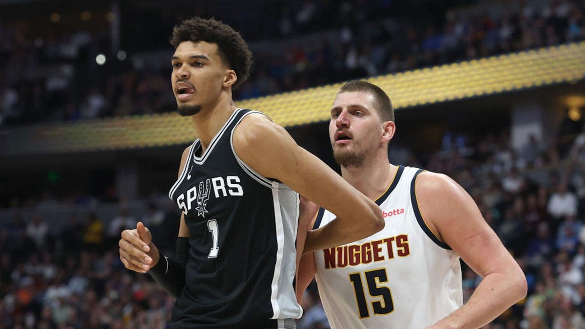 Victor Wembanyama guarded by Nikola Jokic during basketball game at Ball Arena in Denver