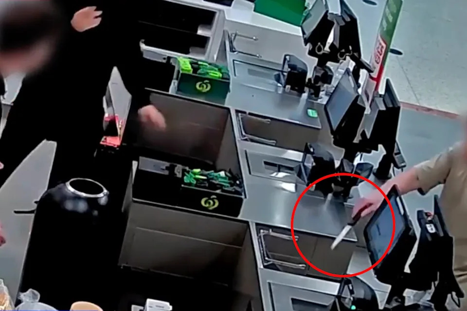 Woolworths staff respond as a man holds a knife at the checkout. 