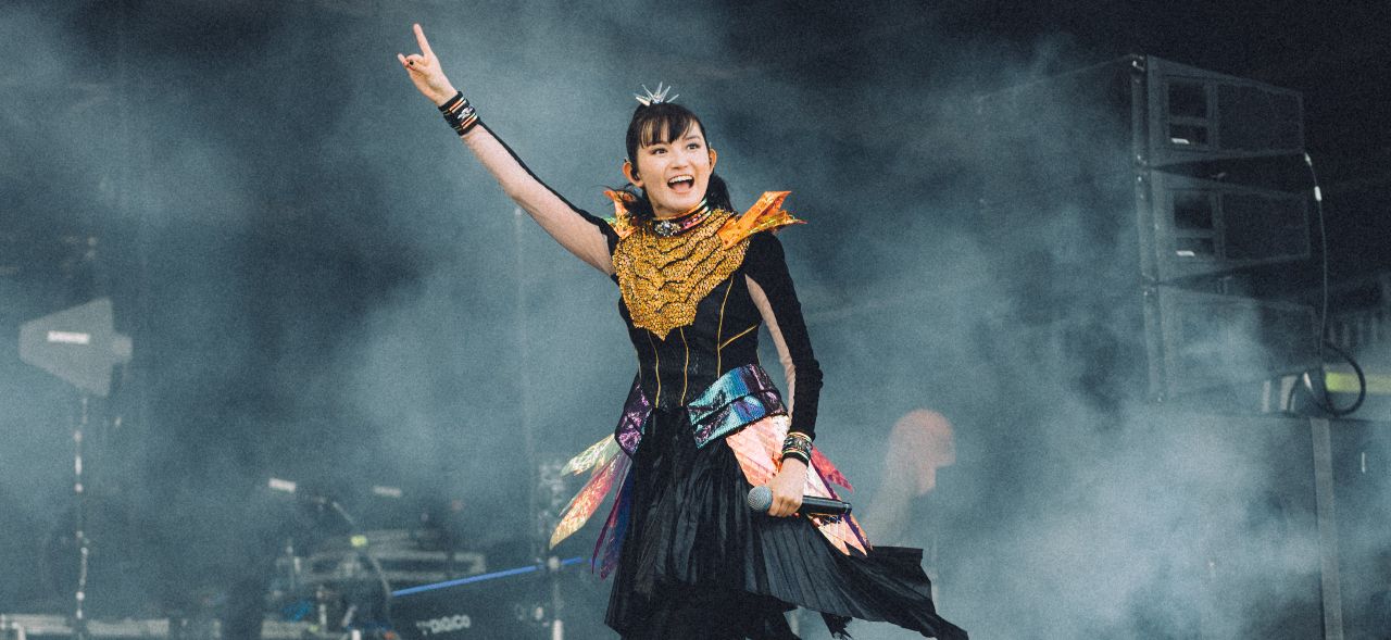 Babymetal smiling and throwing the horns