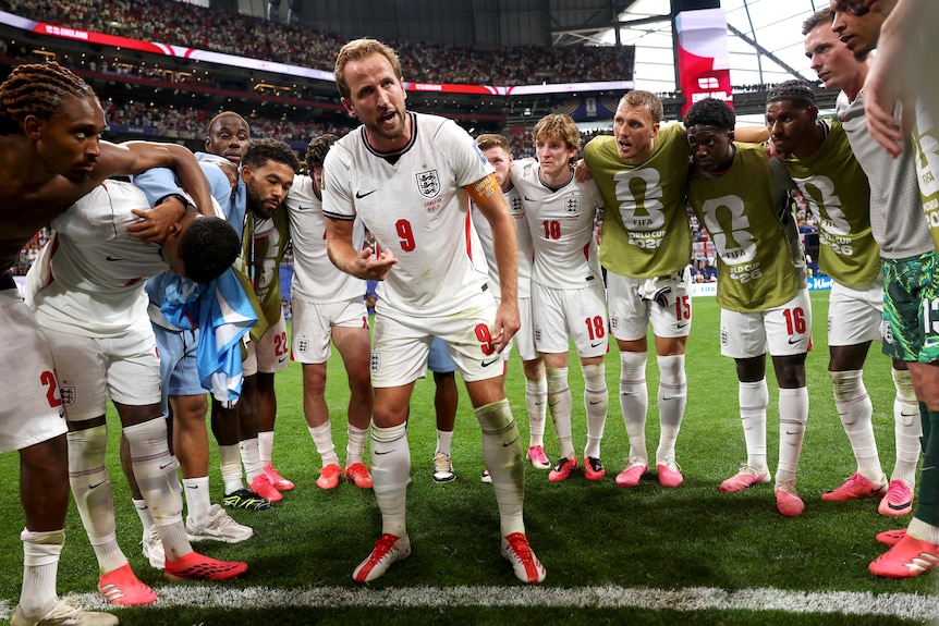 Harry Kane talks in a huddle