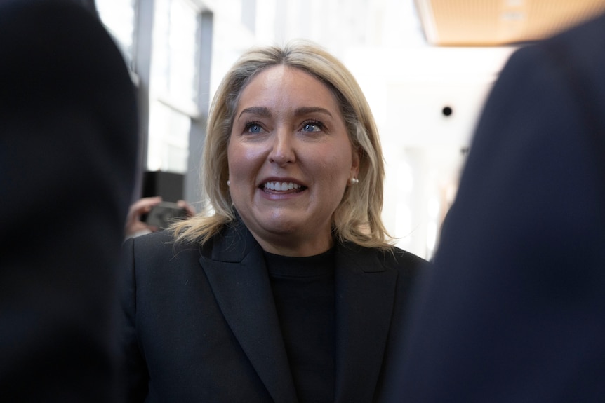 Woman in black shirt and jacket smiling