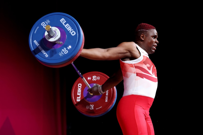 A woman lets her weights drop behind her.