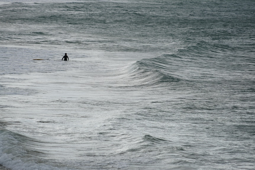Man in ocean with surfboard