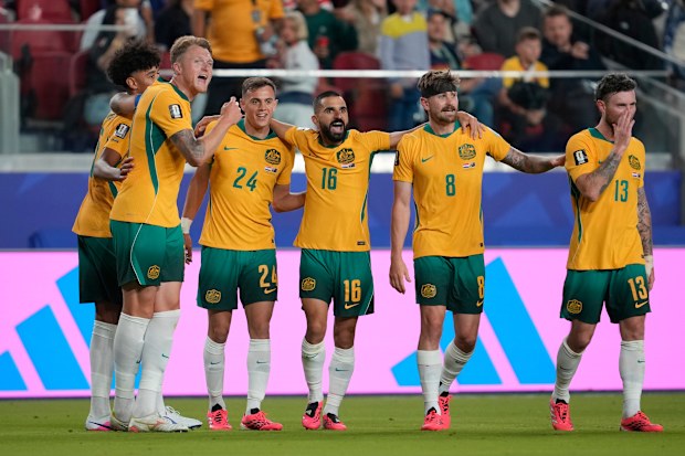Socceroos players celebrate qualifying for the round of 32