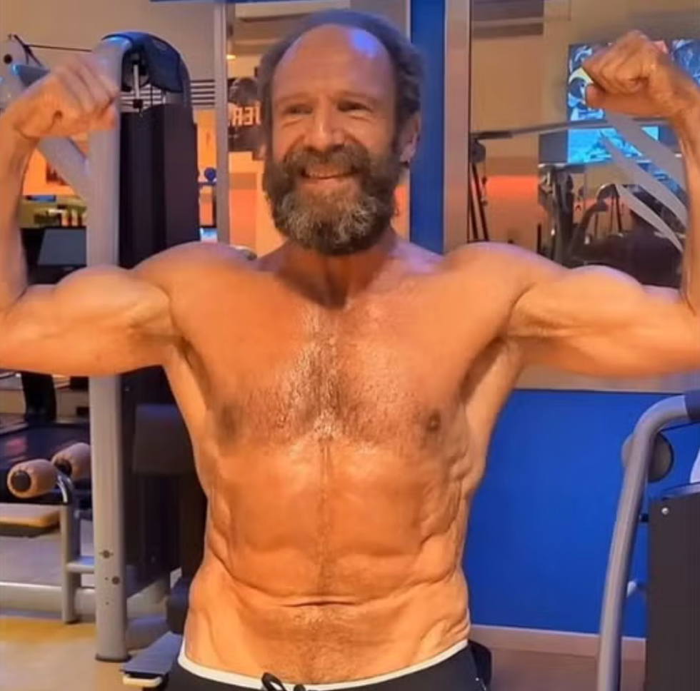 smiling man flexing muscles in a gym. smiling man flexing muscles in a gym.