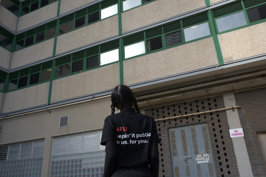 A 4FU female spokesperson with pigtails hair looks at tower block