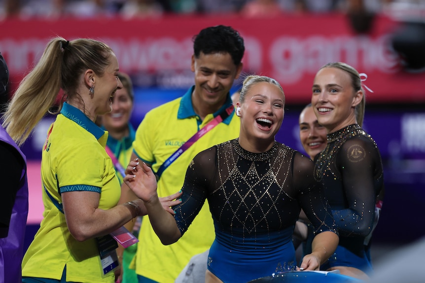 Ruby Pass laughs with her Australian teammates during the women's artistic gymnastics team final.