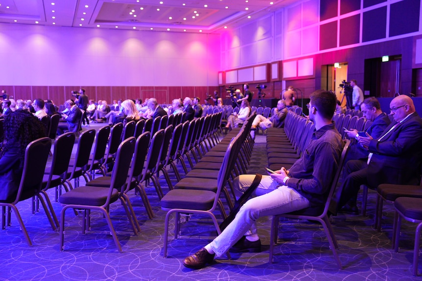 Audience seats in a half-empty room from side angle