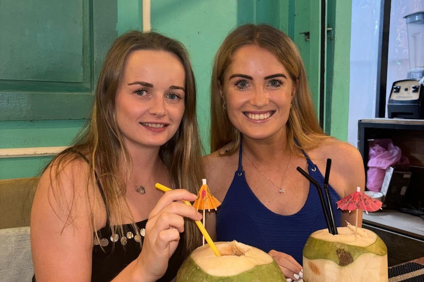 Bethany Clarke and Simone White drinking from coconuts. 