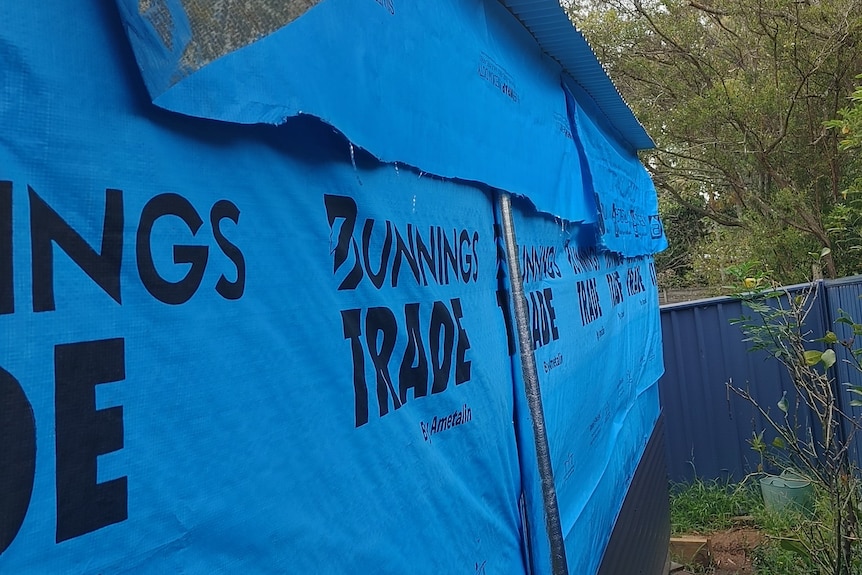 A shed covered in tarp.