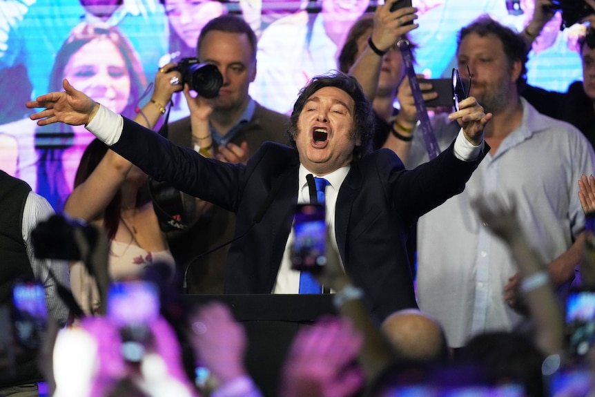 A man cheers with his arms in the air.