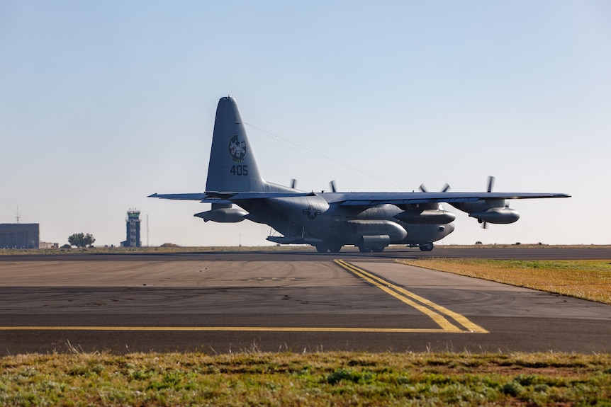 A large miliatry plane on a runway.