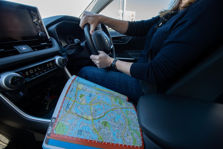 A street directory sits open on a car console