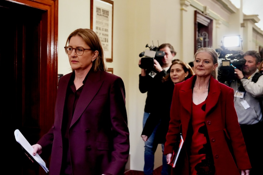 Jacinta Allan and Sonya Kilkenny walk into the Labor caucus meeting followed by a media scrum
