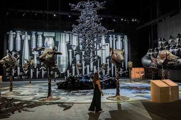 A gallery visitor examines Ai Weiwei’s  Law of the Journey, La Commedia Umana and Circle of Animals/Zodiac Heads at the UK exhibition Ai Weiwei: Button Up!.