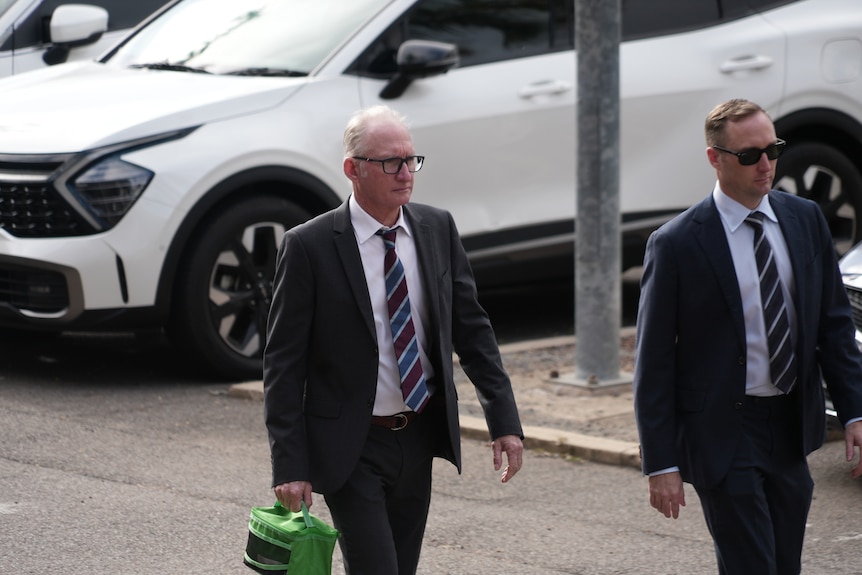 Two suited men walking side by side.