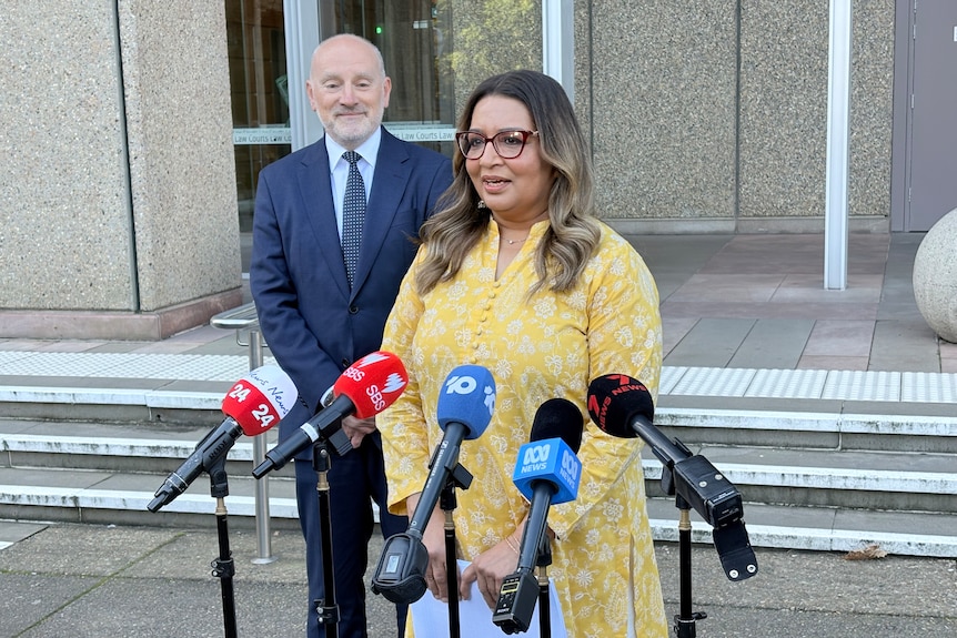 Greens senator Mehreen Faruqi stands behind a microphone addressing the media after a court appearance