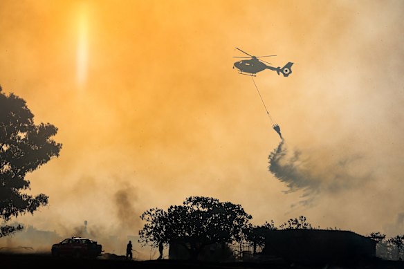 Firefighters use a helicopter to combat wildfires in Rome on Tuesday.