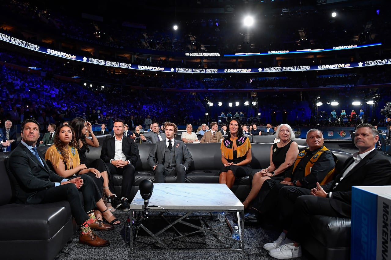 Gavin McKenna, center, sits with family during the NHL hockey draft Friday, June 26, 2026, in Buffalo, N.Y.