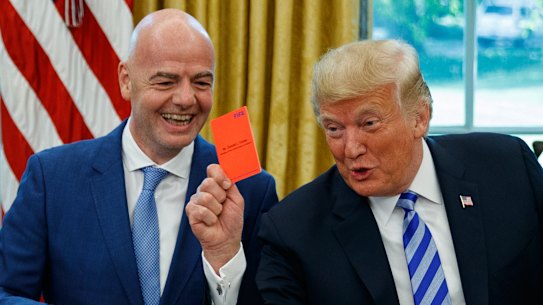  President Donald Trump holds up a red card during a meeting with FIFA president Gianni Infantino in the Oval Office in 2018.