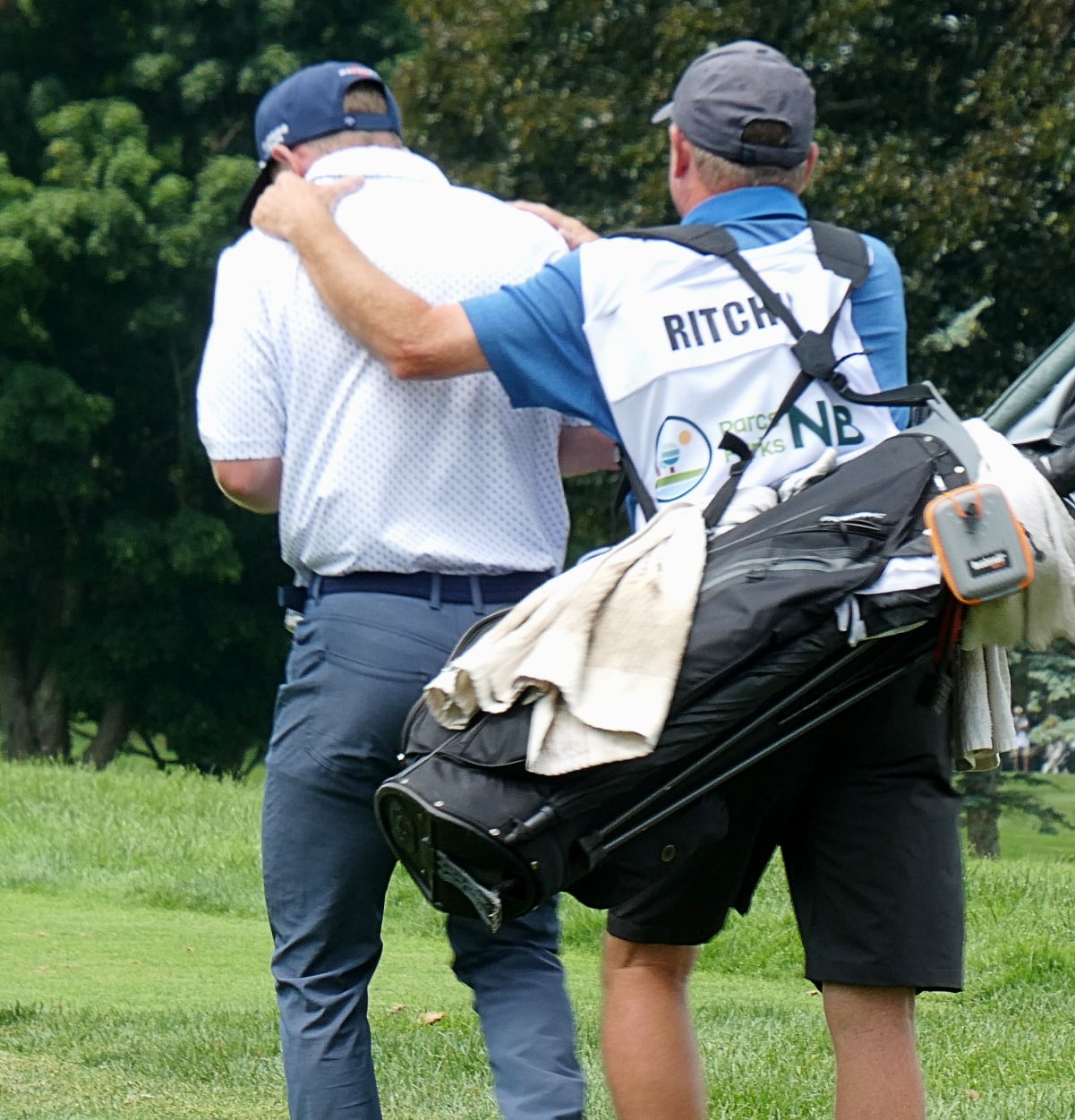 A man put his arms on the shoulders of the man in front of him in an excited celebration.
