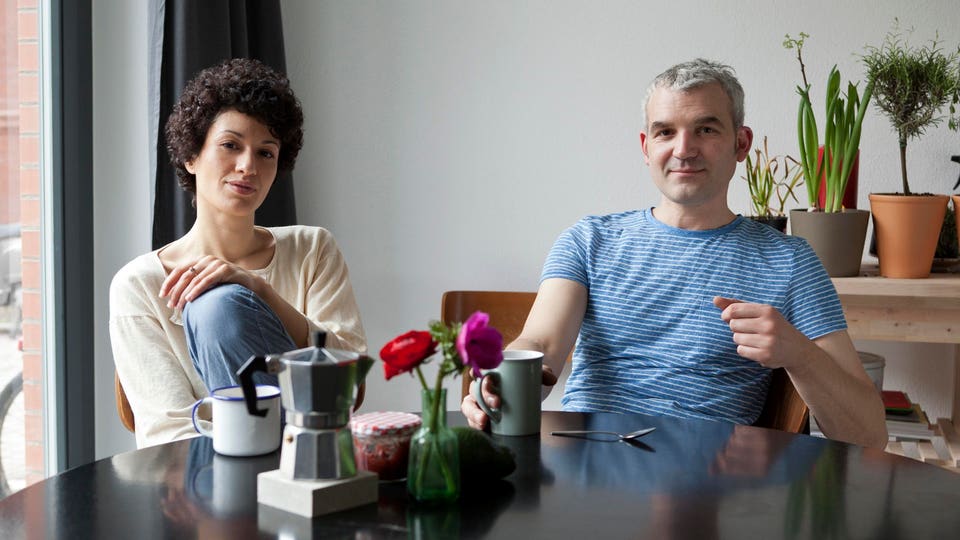 A hip mixed age couple having breakfast in their modern dining table