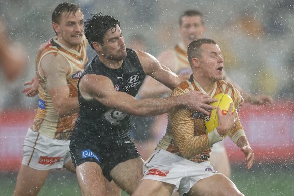 Jack Ginnivan of the Hawks is tackled by George Hewett of the Blues.