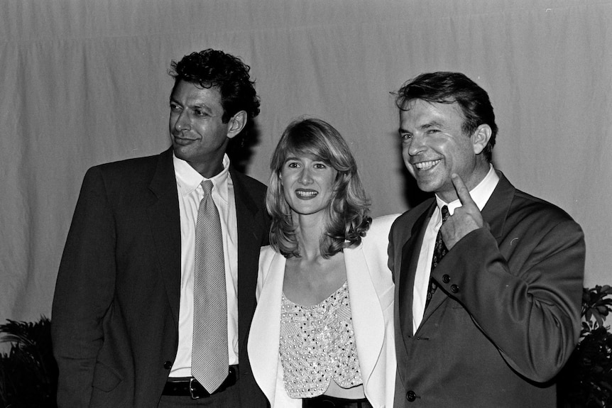 Black and white image of two men and a woman