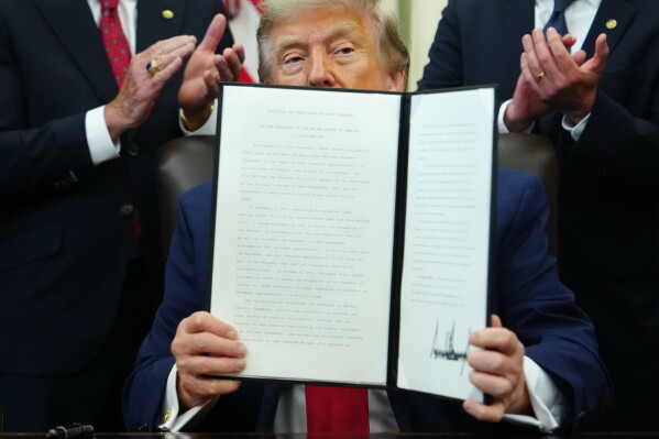 President Donald Trump holds an executive order modifying the Bears Ears National Monument in the Oval Office of the White House, Monday, July 13, 2026, in Washington. (AP Photo/Julia Demaree Nikhinson)