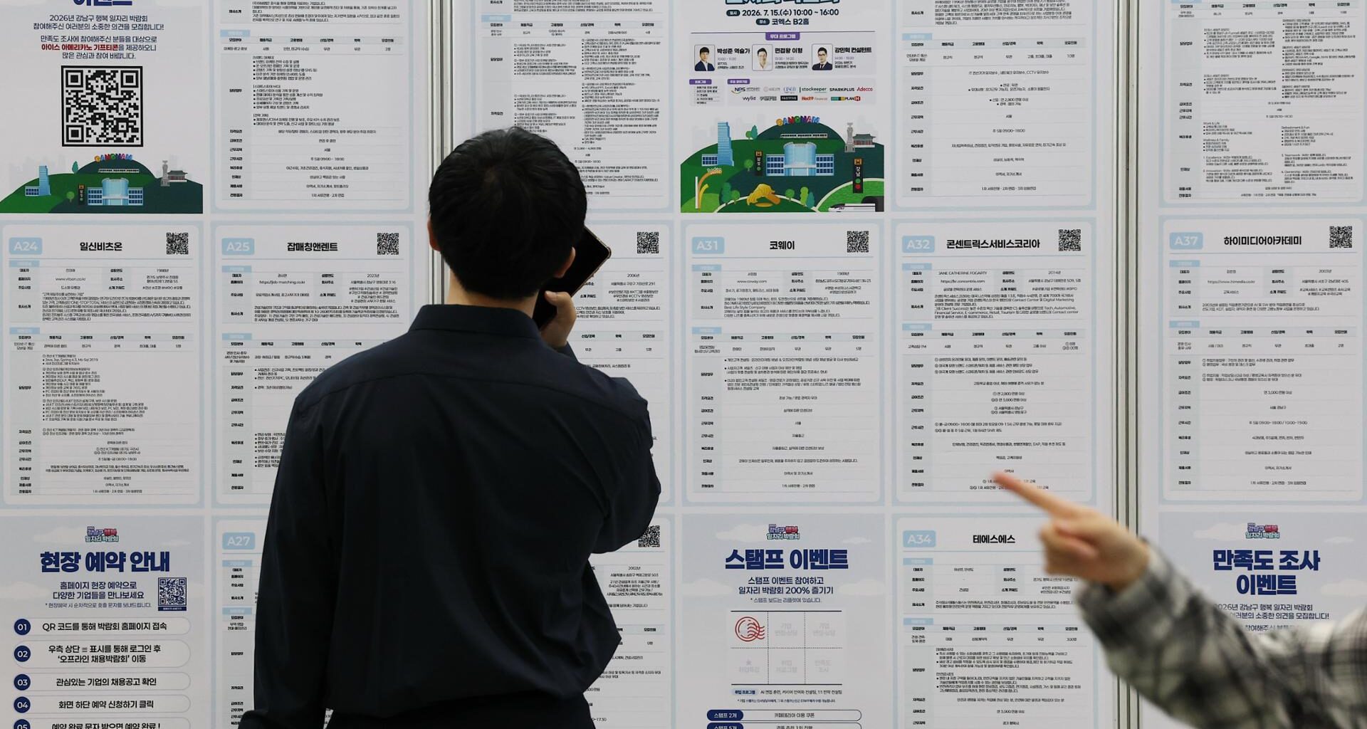 Job seekers look at job postings at a job fair in Seoul, Wednesday. Yonhap