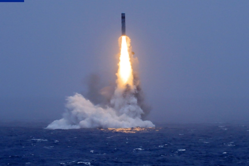 A rocket launches from the sea leaving.