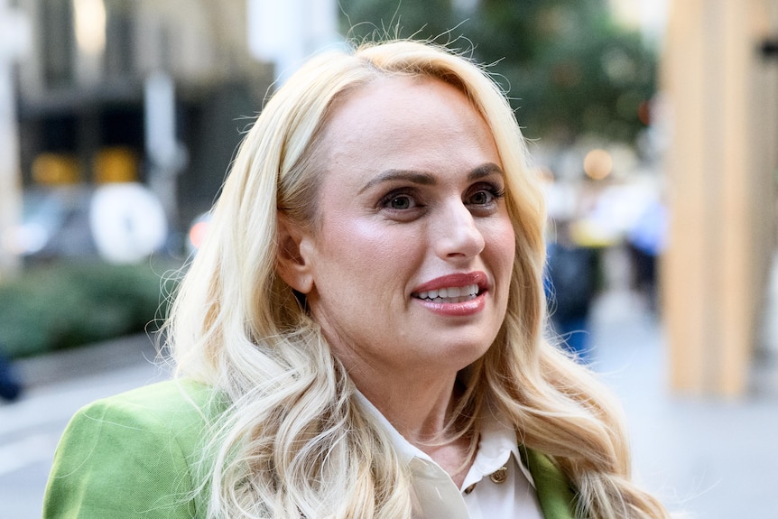 Rebel Wilson outside court wearing a green jacket.