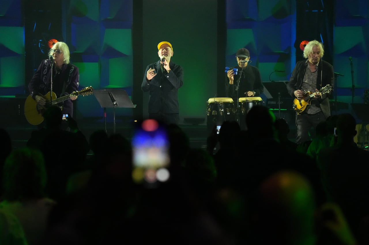 Members of the band R.E.M. perform on stage in 2024.