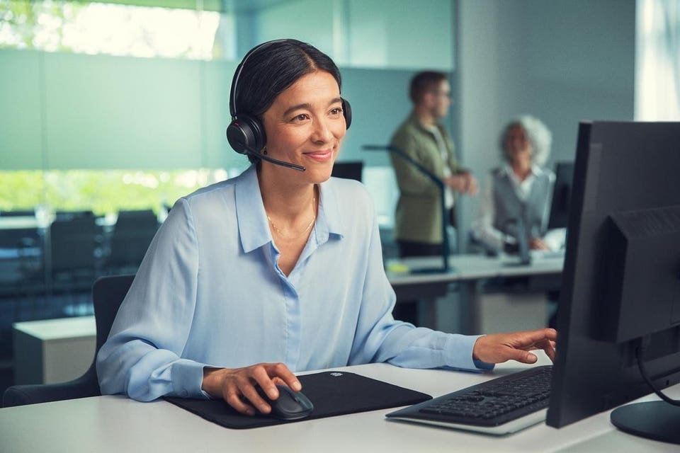 Woman at desk wearing EPOS IMPACT 1000 headset