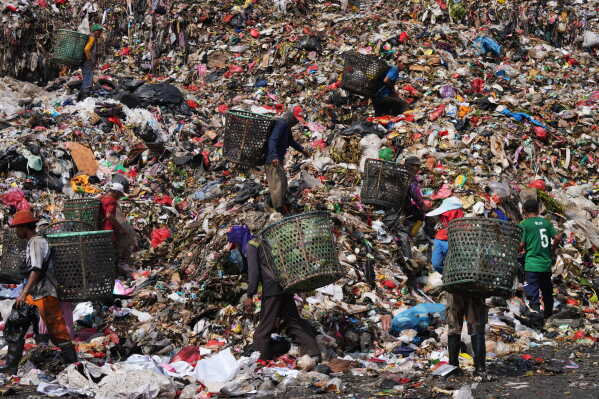 Waste pickers look for recyclable items in a pile of garbage at the Bantargebang landfill on the outskirts of Jakarta, Indonesia, Monday, July 6, 2026. (AP Photo/Tatan Syuflana)