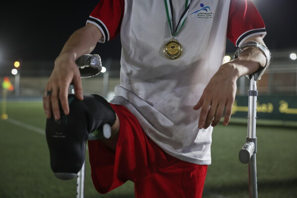 A player wearing a winner's medal rests on his crutches after the final of Syria's first football tournament for people with disabilities at Al-Muhafaza Stadium in Damascus, Syria, Wednesday, July 29, 2026. (AP Photo/Ghaith Alsayed)