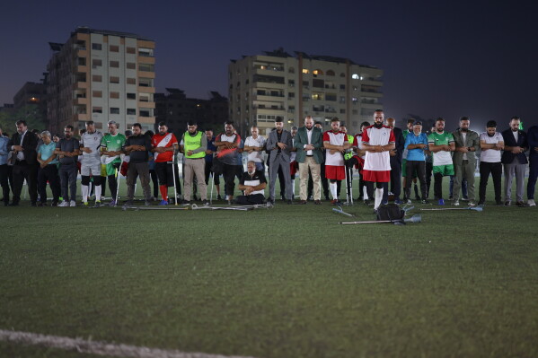 Players, coaches and officials pray before the final of Syria's first football tournament for people with disabilities at Al-Muhafaza Stadium in Damascus, Syria, Wednesday, July 29, 2026. (AP Photo/Ghaith Alsayed)
