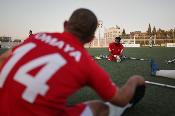 Players from Omayya Club stretch before the final of Syria's first football tournament for people with disabilities at Al-Muhafaza Stadium in Damascus, Syria, Wednesday, July 29, 2026. (AP Photo/Ghaith Alsayed)
