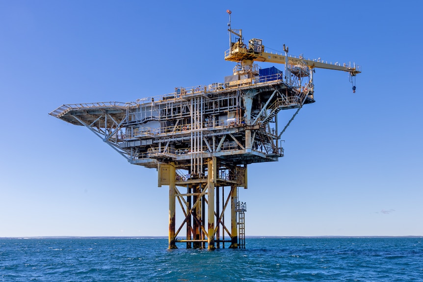 With yellow legs and frame, the structure sits isolated within the sea.