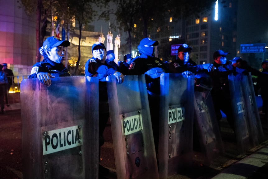 Riot police line up with shields to protect England's hotel