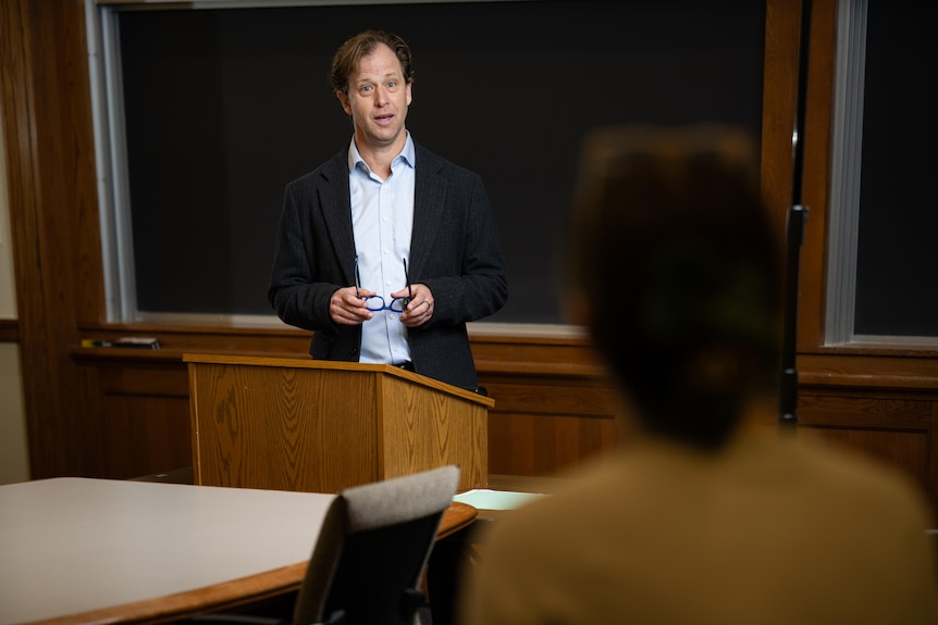 A man talks in a classroom.