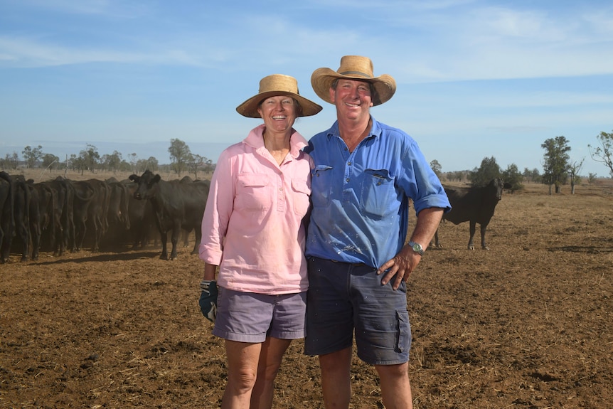 two farmers smile in brown paddock