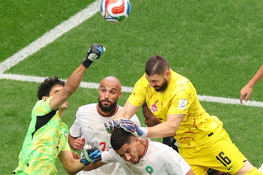 Yassine Bounou punches clear against Maxime Crépeau
