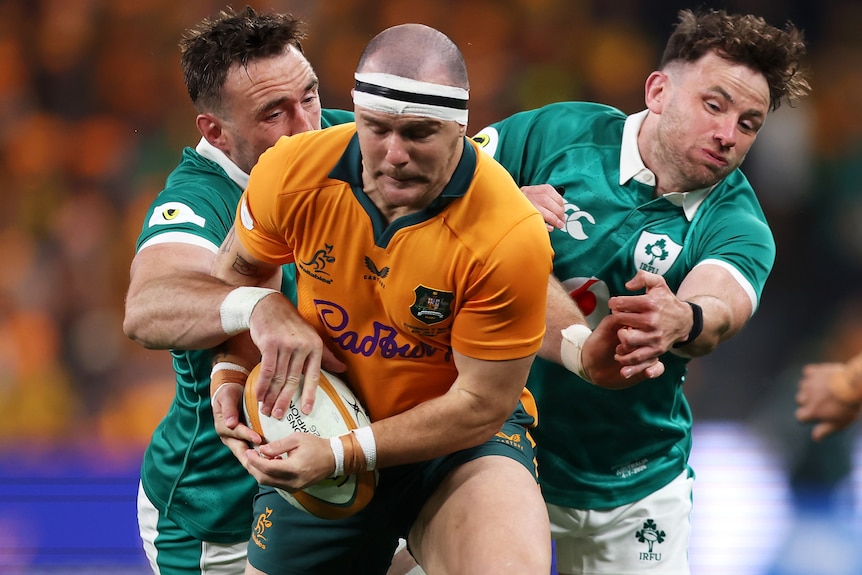 Dylan Pietsch holds the ball while being tackled by Ireland.