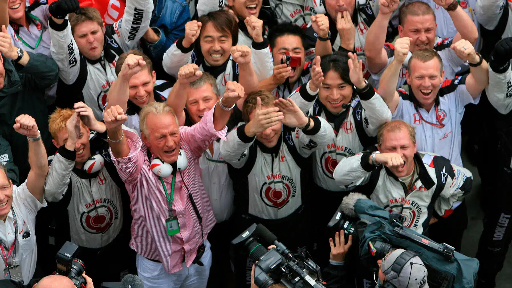 Honda mechanics and John Button (father of Jenson) celebrate at the end of the wet 2006 Hungarian Grand Prix