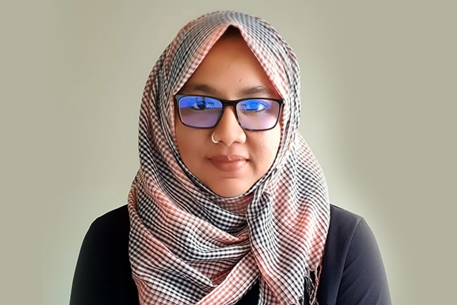 A woman in a hijab with glasses