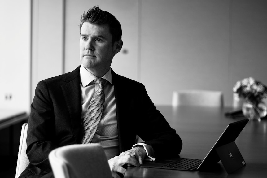 A man looks off camera wearing a suit