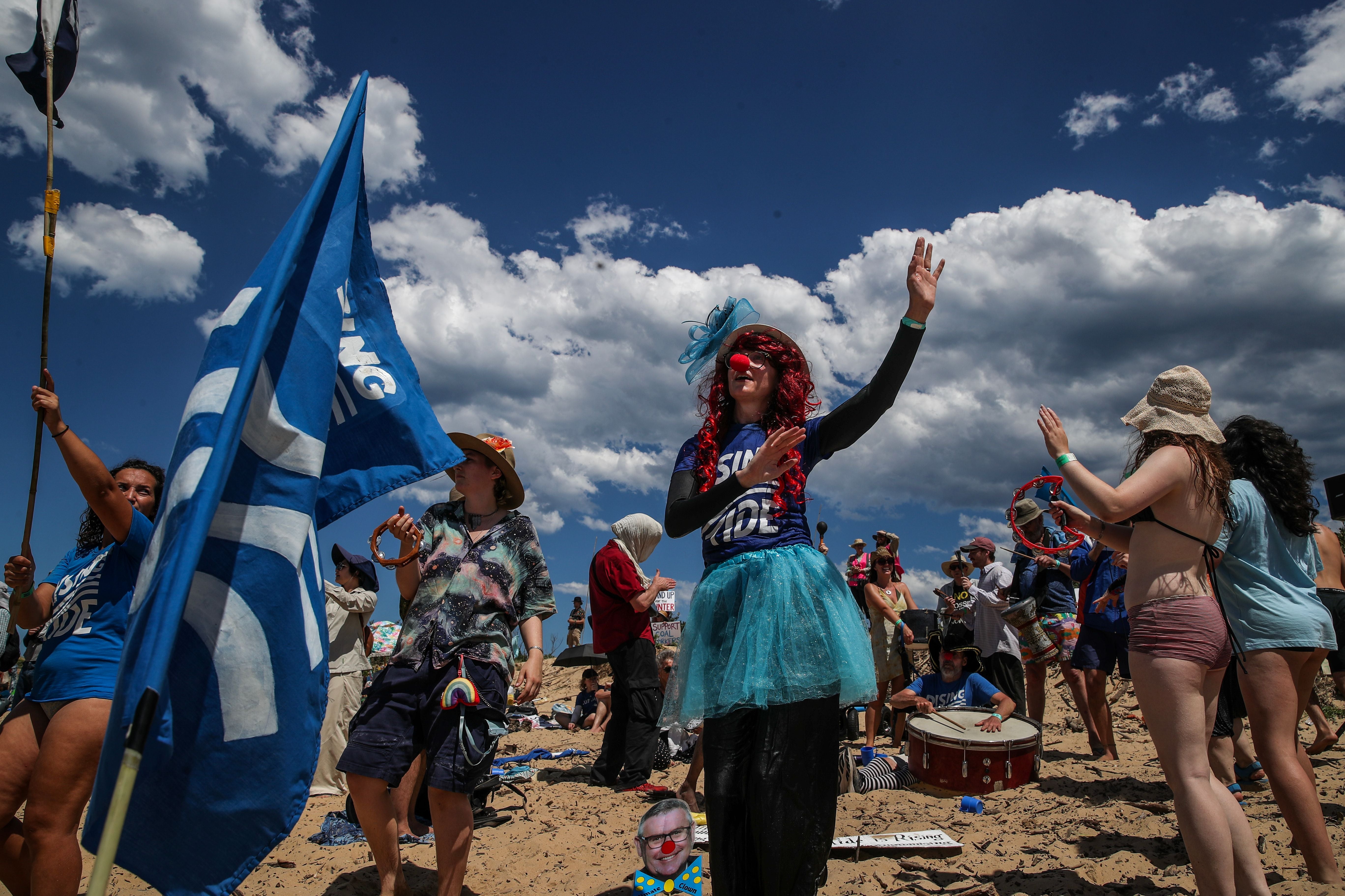 Climate protestors dance as they continue their attempt to disrupt the access to Newcastle coal port in protest for climate action at Horseshoe Beach on 30 November 2025 in Newcastle, Australia