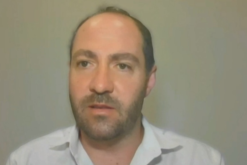 A man with short cut hair and a groomed beard.