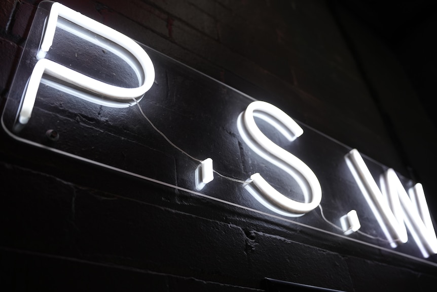 A neon sign showing the letters 'PSW'.